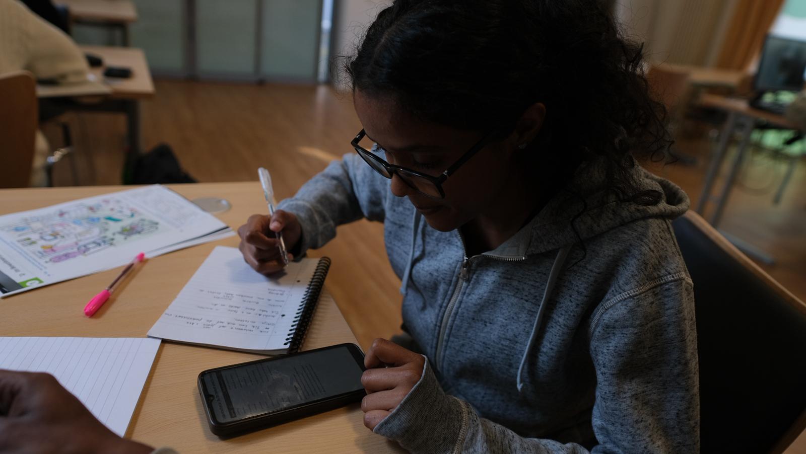 Student taking notes during a language lesson